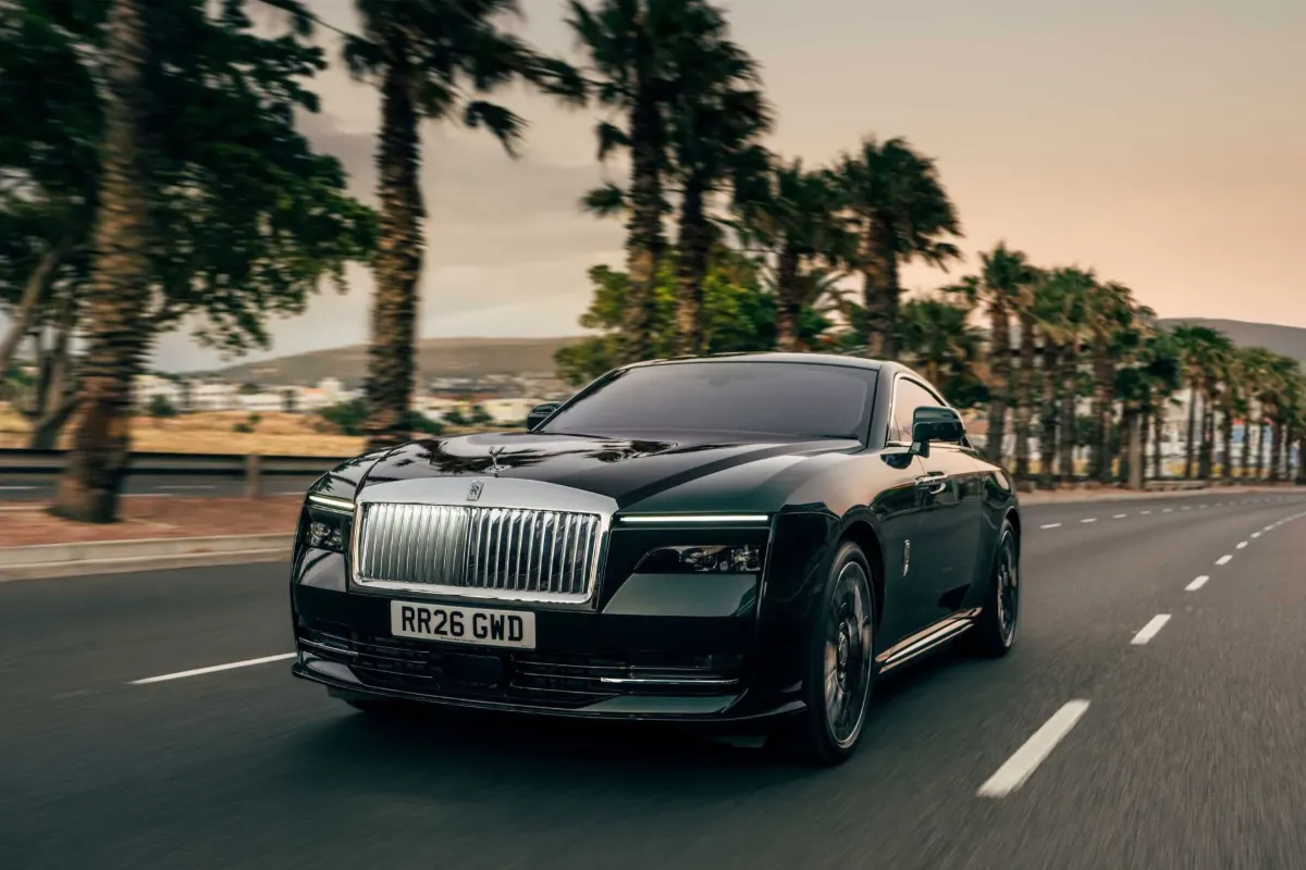 Rolls-Royce Spectre Series II med vožnjo, pogled od spredaj ob palmah